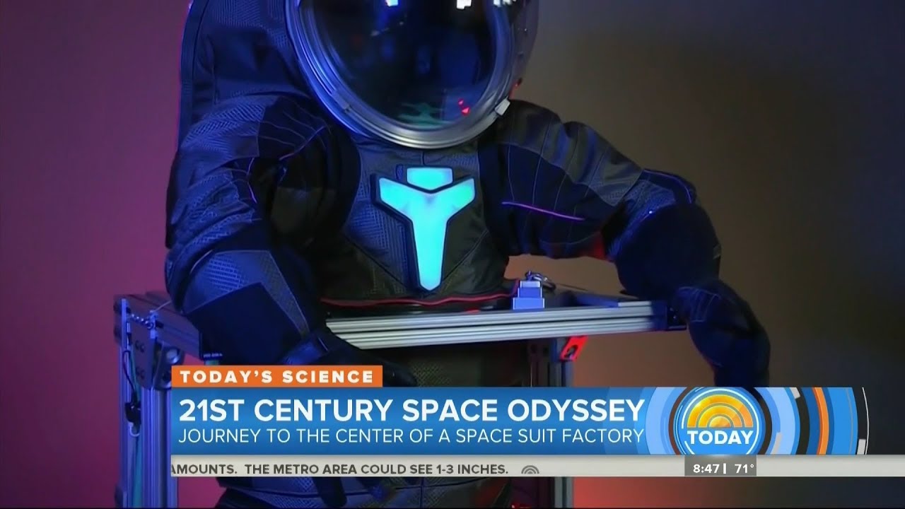 A person in a modern space suit equipped with the latest space suit technology stands behind a podium, featured on a television show titled "21st Century Space Odyssey.